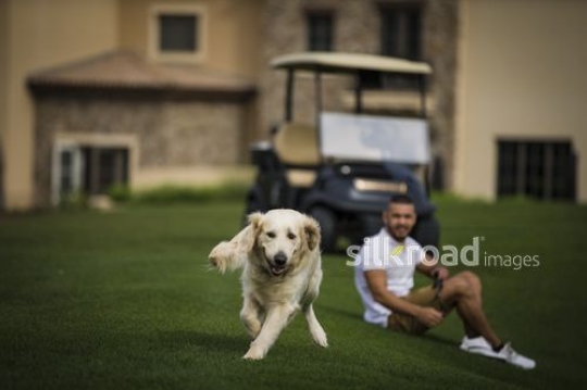Arab man sitting down looking at the dog run|-