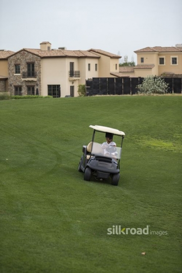 Young Arab man driving the Golf Cart|-