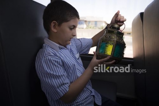 Young student admiring the Ramadan Lantern in his hand|-