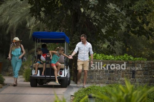 Western parents helping kids get off the golf cart|-