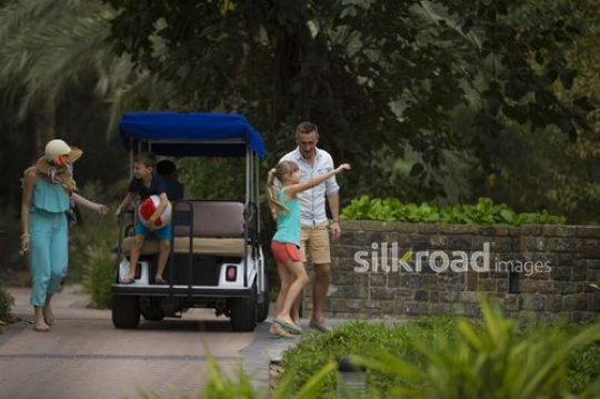 Western Family getting off the golf cart at the resort|-