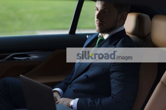 Western Businessman sitting inside of the luxury car|