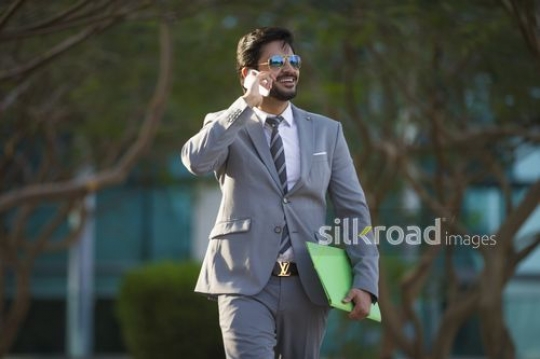 Businessman dressed in a suit talking on the phone |-