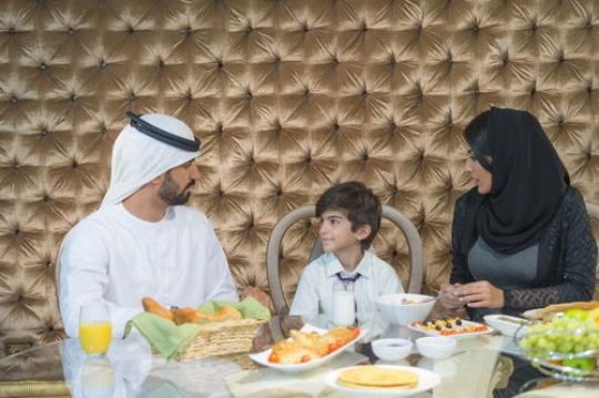 Arab parents and their son sitting for breakfast |-