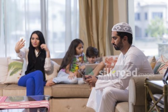 Middle Eastern family using their devices|
