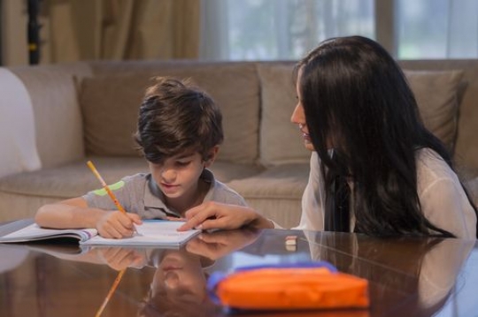 Middle eastern mother helping her son with his homework|-
