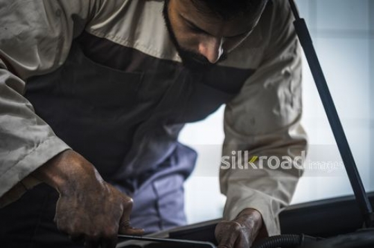 Mechanic working on the car at the repair shop|-