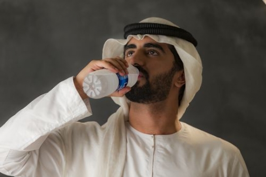 Arab man drinking water|-