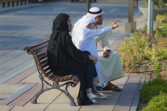 Middle eastern family dressed in traditional attire looking at the view|-