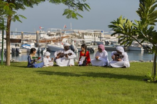 Middle eastern family sitting on the grass celebrating national day|-