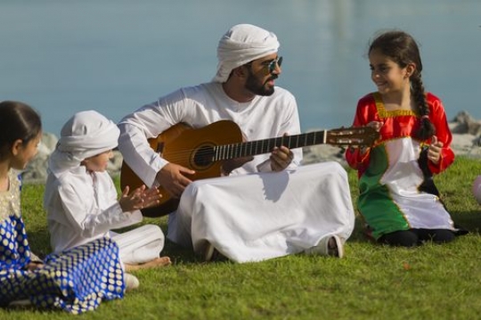 Arab man and three kids celebrating national day|-