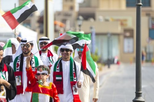 A group of family and friends representing their country during a National Day parade|