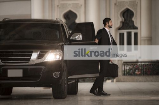 Arab Businessman closing the door of the car|