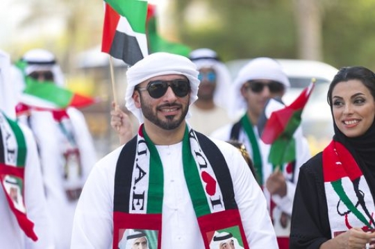 Arabian family dressed in the UAE traditional attire at a National Day parade|