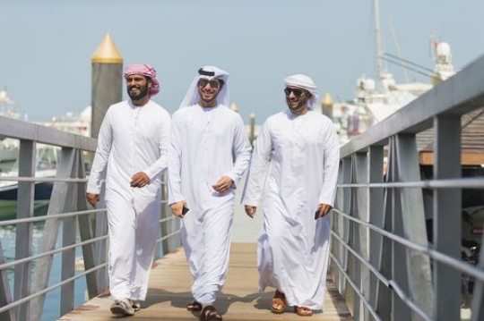 Arab men walking on the dock talking to each other|