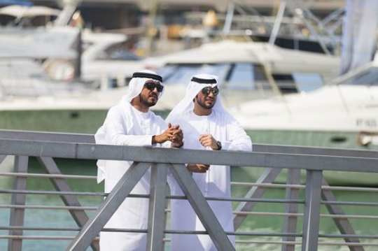 Arabian men standing by the dock with a background of burj al arab|