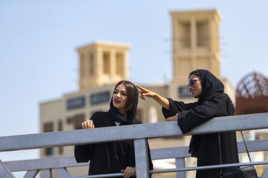 Women standing by the dock talking to each other|