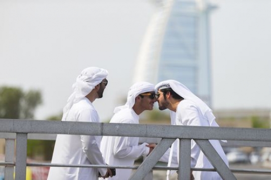 Arab man greeting young boy in the traditional Emirati way|