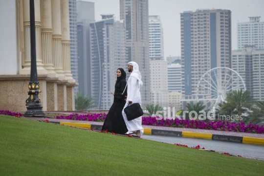 Businessman and Businesswoman walking together outside |-