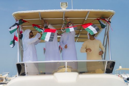 Arab men celebrating National Day while decorating the Yacht|