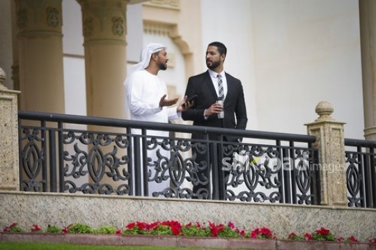 Middle Eastern businessmen standing and talking to each other |-