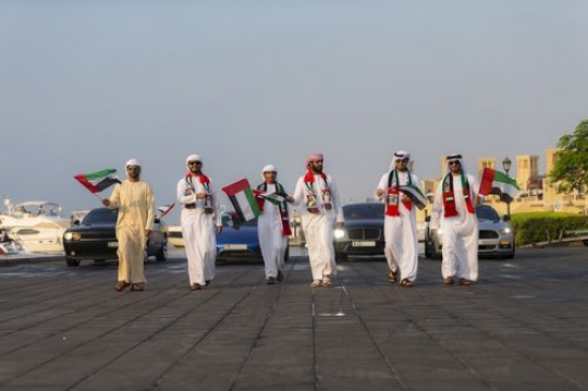 Friends and family followed by luxurious cars celebrating National Day|-