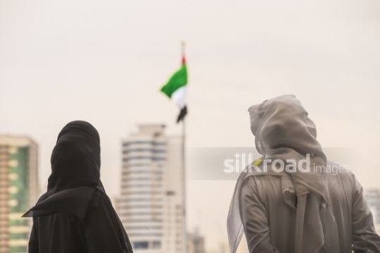 Medium shot of an Arab man and Woman standing representing their country|-