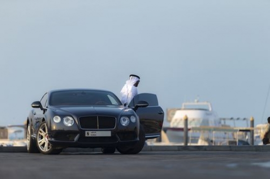 Arab man exiting the black colored vehicle|-
