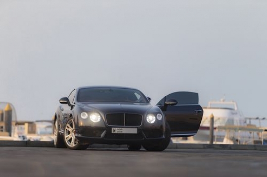 Man exiting his black luxury car|-