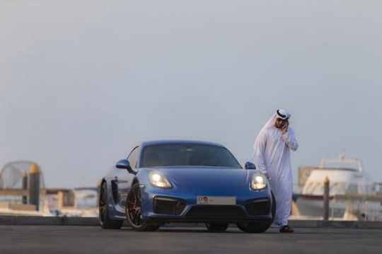 Arab man talking on the phone next to the luxury car|-