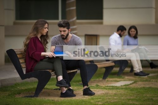 Students sitting on the bench together|