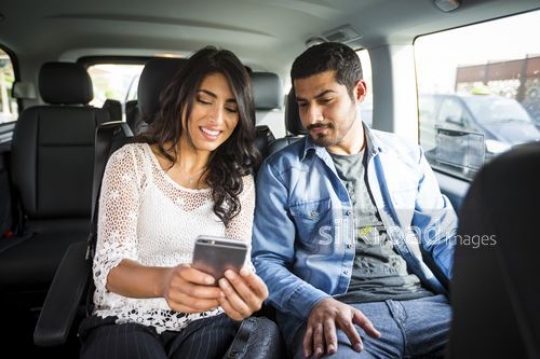 Woman sitting using her mobile with the man in the car|-