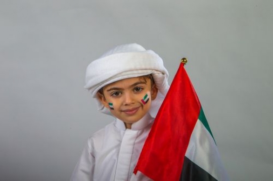Emirati boy carrying a flag