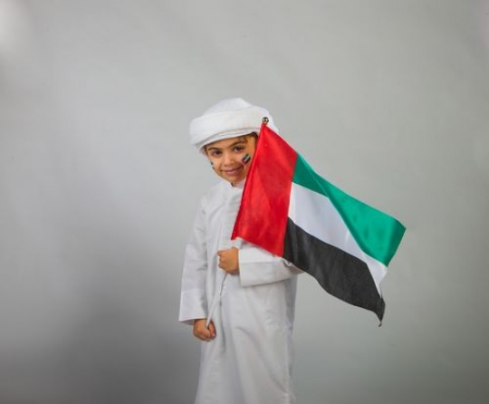 Emirati boy carrying a flag
