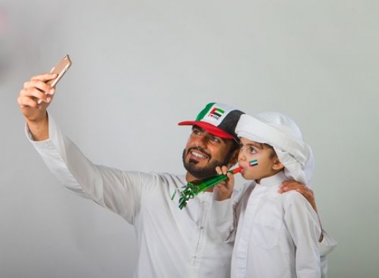 Arab Father and Son taking a Selfie for National Day