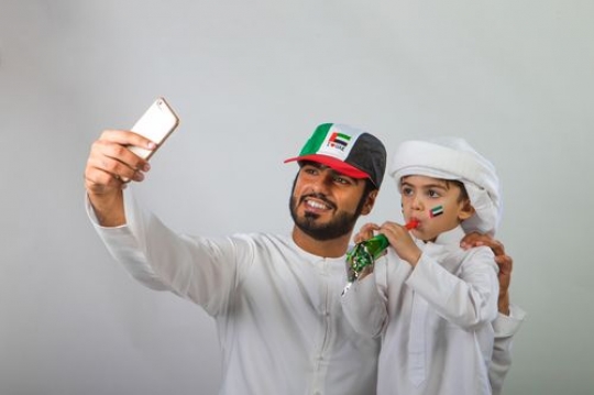 Arab Father and Son taking a Selfie for National Day