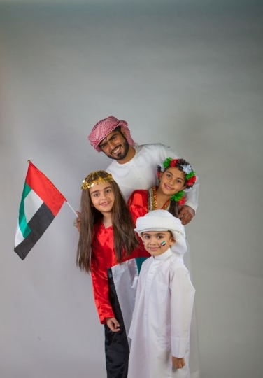 Middle Eastern family taking a photo together for National Day