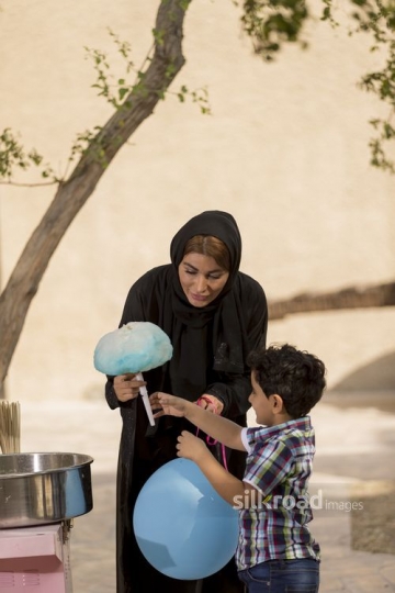 Arab mother giving her son the cotton candy|-