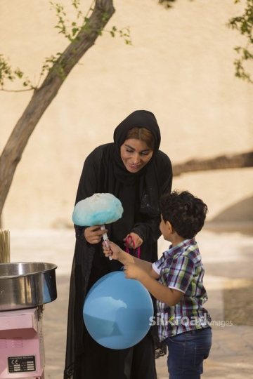 Arab mother giving her son Cotton Candy|-
