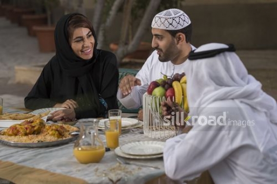 Middle Eastern family sitting together on the dinning table|-