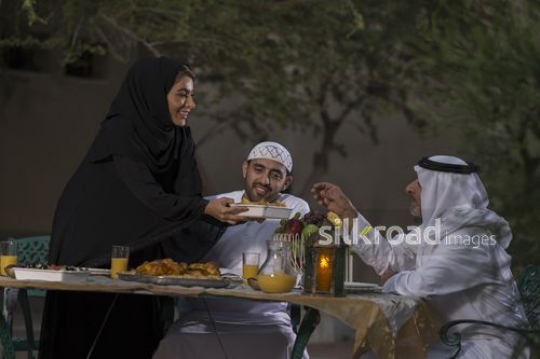 Middle Eastern woman offering food to the Middle Eastern man|-