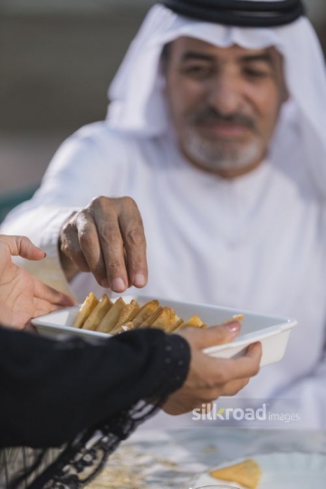 Arab woman offering the man food|-