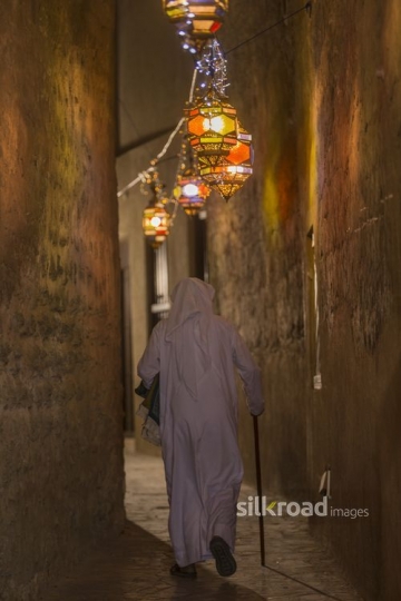 Arab man walking through the pathway of Ramadan Lanterns|-