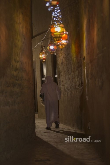 Arab man carrying a prayer rug during Ramadan|-