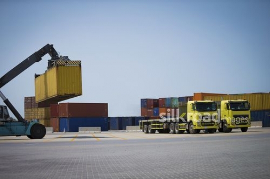 Construction Truck carrying Cargo to the Truck at the Port|-