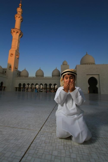 kid in a mosque yard preying