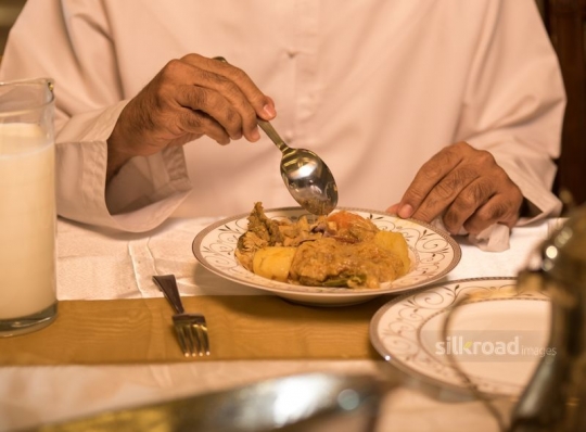 man eating Arabic food|-