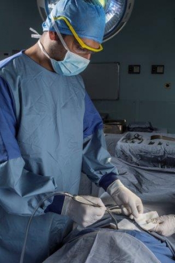 A Surgeon Holding a Suction at