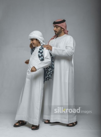 Arabian father helping his son with his school bag