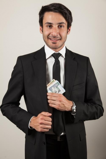 businessman putting money in his pocket